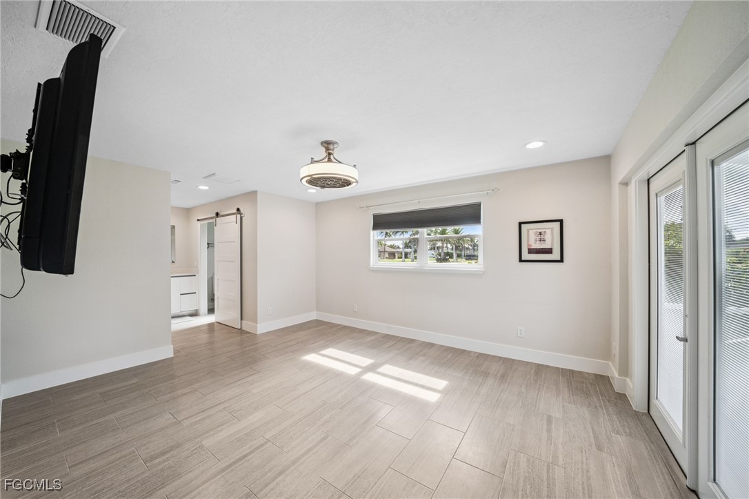 422 Coral Drive Cape Coral, FL 33904 - Photo 26 of 43 wooden floor in an empty room with a window