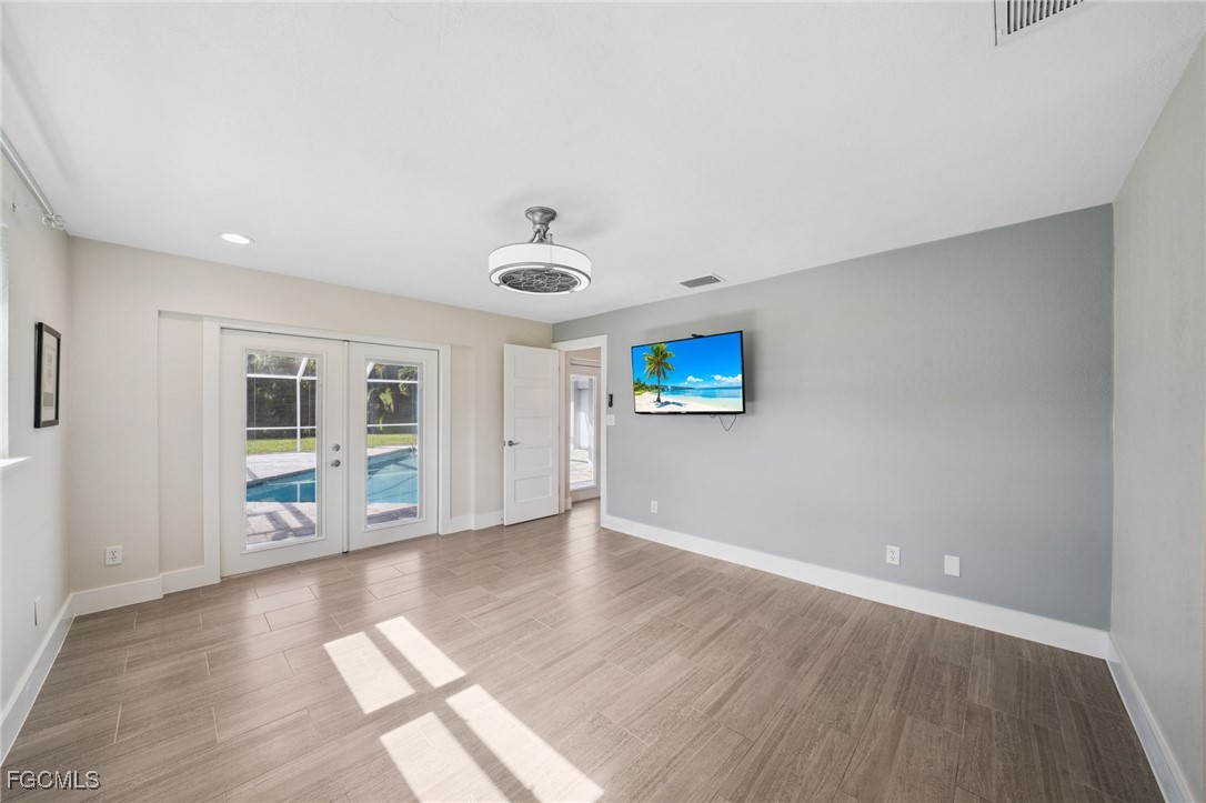422 Coral Drive Cape Coral, FL 33904 - Photo 28 of 43 an empty room with wooden floor and windows