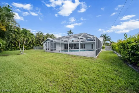 a view of a house with a yard and potted plants