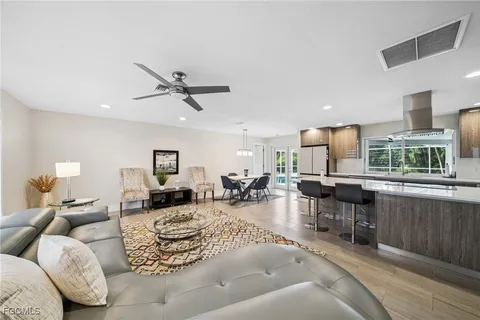 a living room with furniture kitchen view and a large window