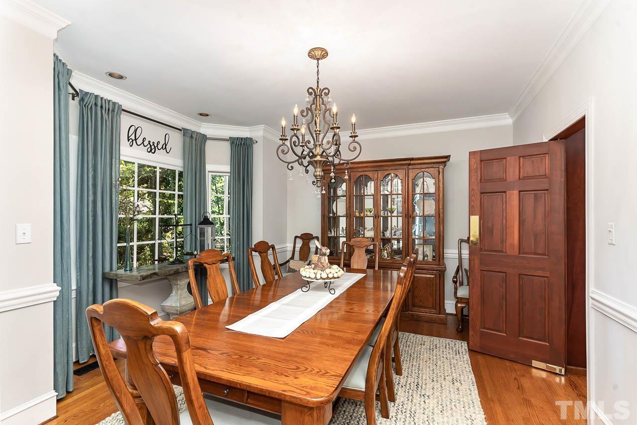 7512 Rainwater Road Raleigh, NC 27615 - Photo 19 of 45 a dining room with furniture a chandelier and wooden floor
