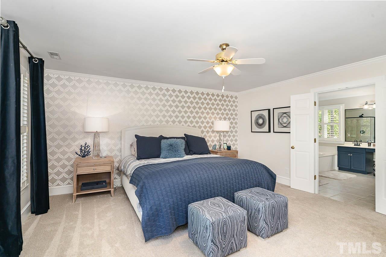 7512 Rainwater Road Raleigh, NC 27615 - Photo 33 of 45 a bedroom with a bed and a chandelier