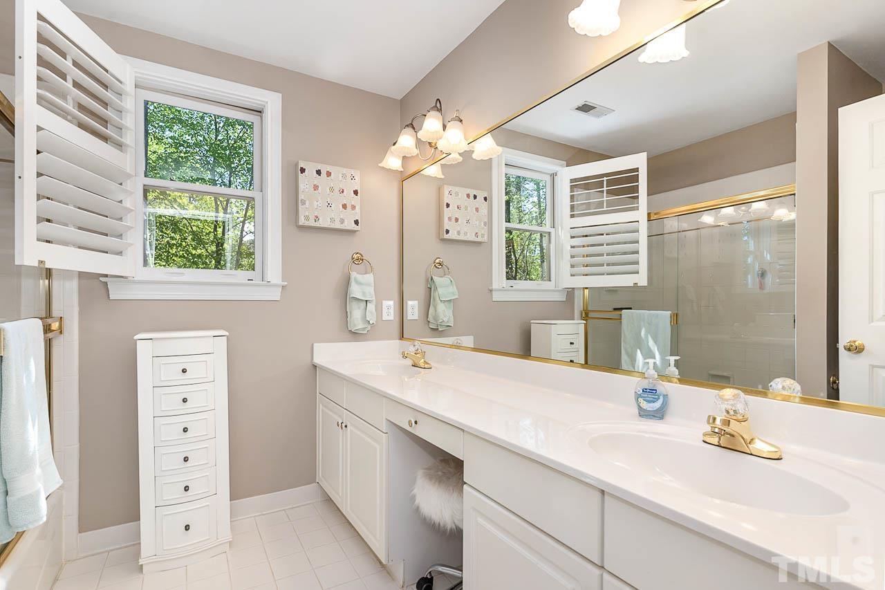 7512 Rainwater Road Raleigh, NC 27615 - Photo 35 of 45 a bathroom with a double vanity sink window and a mirror