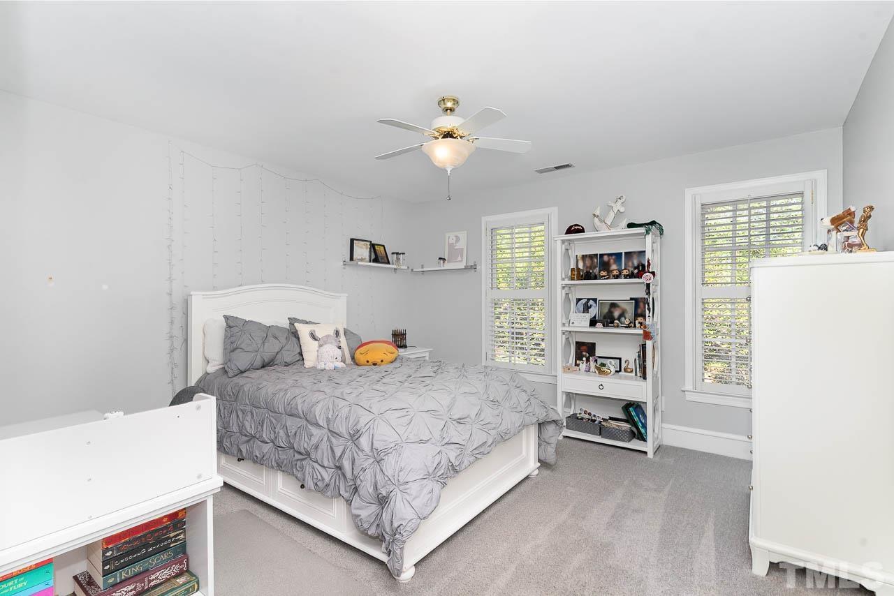 7512 Rainwater Road Raleigh, NC 27615 - Photo 38 of 45 a bedroom with a bed and a chandelier