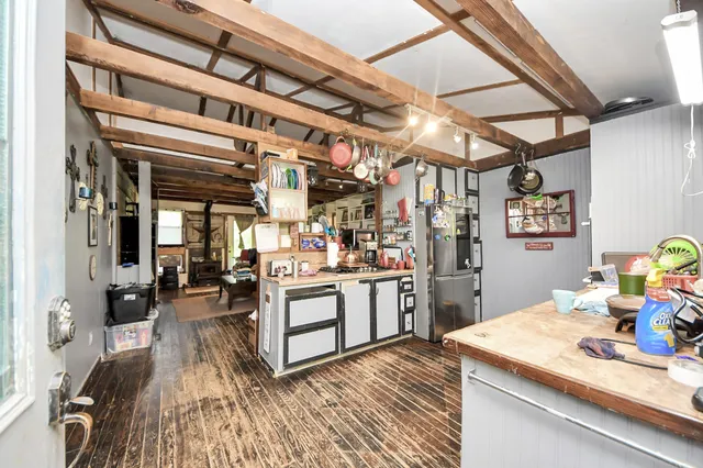 a kitchen with stainless steel appliances granite countertop a sink and wooden floor