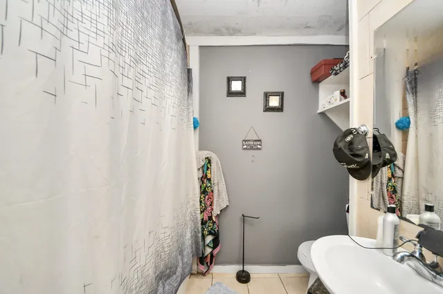 a bathroom with a sink toilet and shower curtain