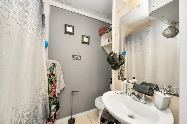 a bathroom with a sink and mirror with toilet
