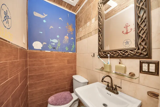 a bathroom with a toilet sink and mirror