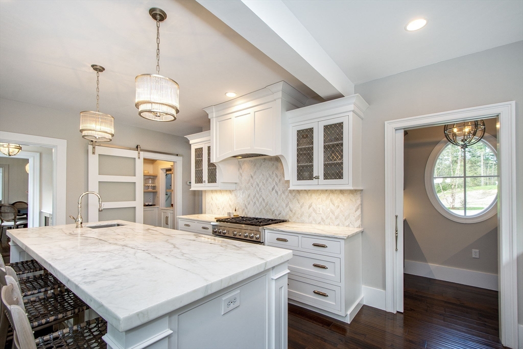 41 Brigantine Circle Norwell, MA 02061 - Photo 4 of 37 a kitchen with stainless steel appliances granite countertop a stove a sink dishwasher a dining table and chairs with wooden floor