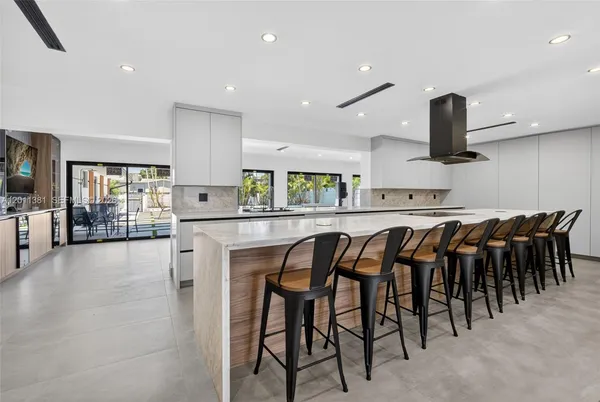 a kitchen with stainless steel appliances granite countertop table chairs sink and stove