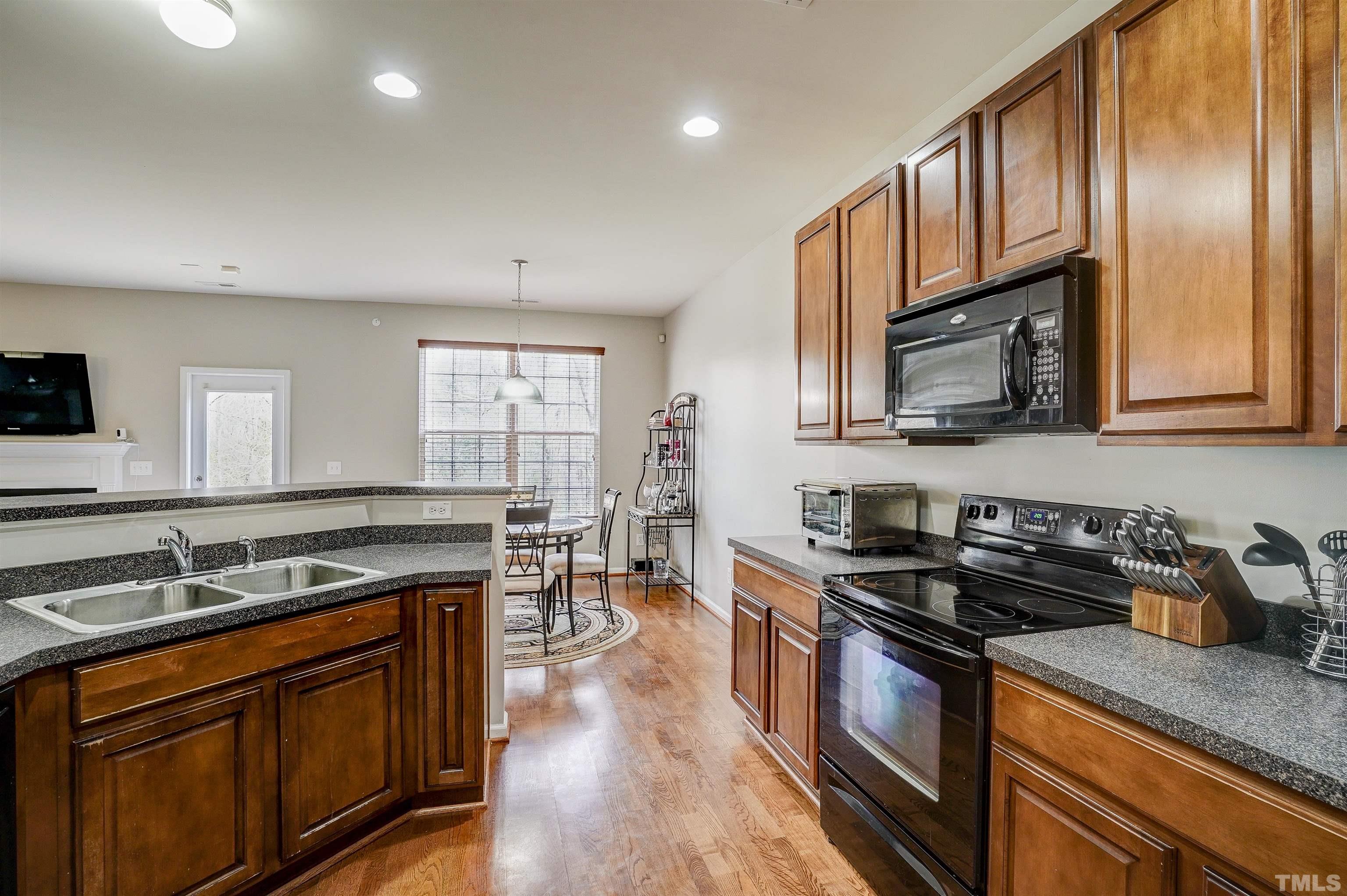301 Cottesbrook Drive Wake Forest, NC 27587 - Photo 7 of 32 a kitchen with stainless steel appliances granite countertop a sink stove microwave and cabinets