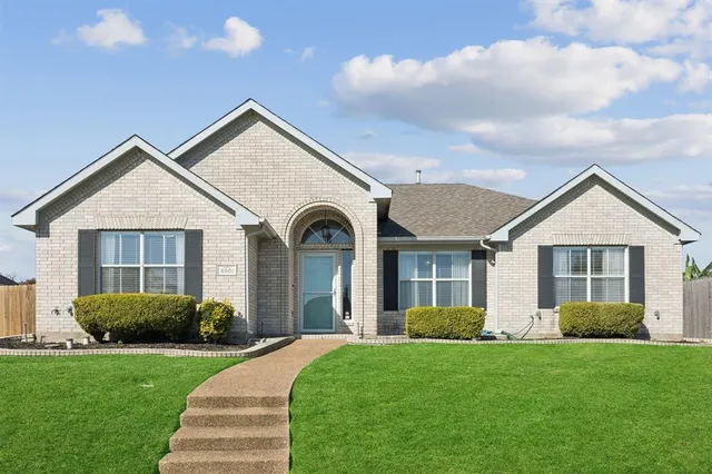 a view of a house with a yard and potted plants