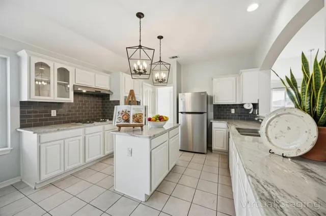 a kitchen with a sink refrigerator and cabinets