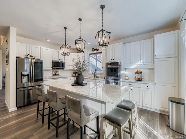 a kitchen with refrigerator a sink and chairs