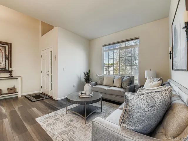 a living room with furniture a rug and a window