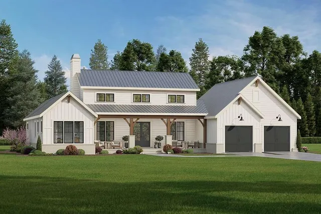 a front view of a white house with a garden