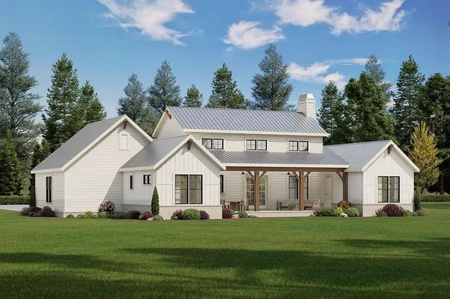 a front view of a white house with a garden