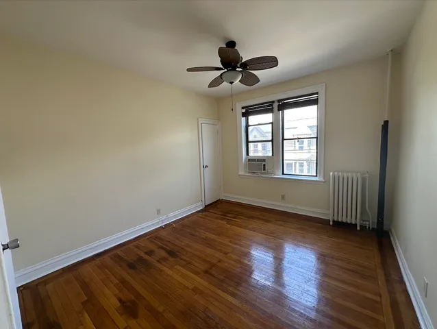a view of an empty room window and wooden floor