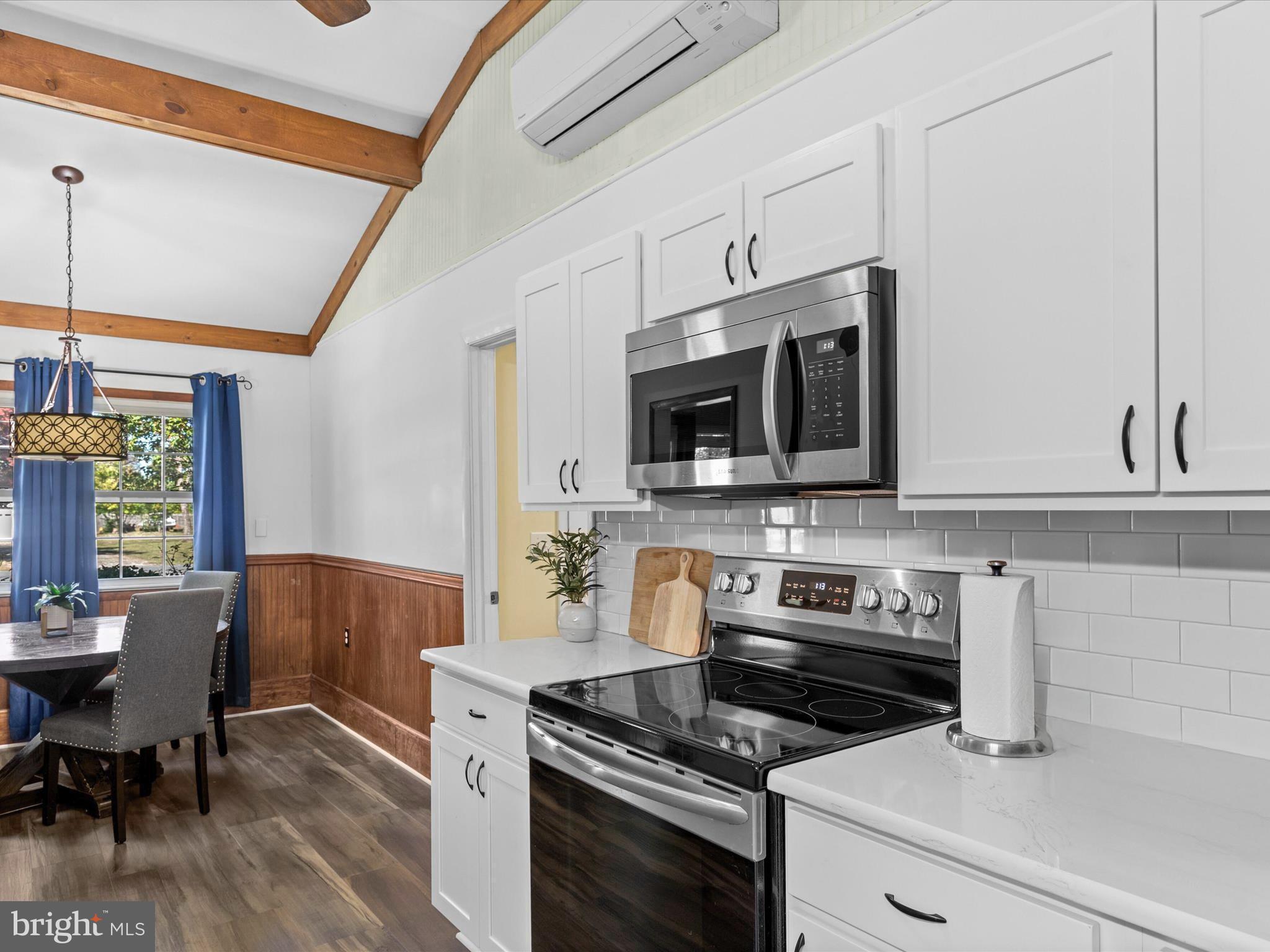 26905 Mt Vernon Road Princess Anne, MD 21853 - Photo 15 of 74 a kitchen with a stove a microwave and wooden floor