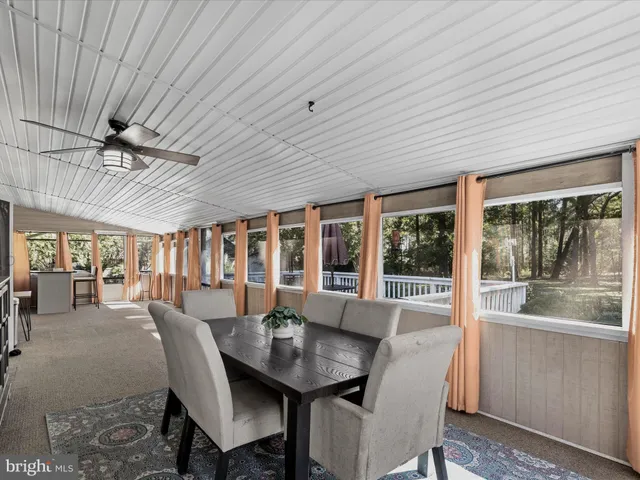 a dining room with furniture a chandelier and wooden floor