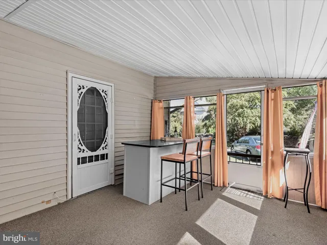 a living room with furniture a dining table and a floor to ceiling window