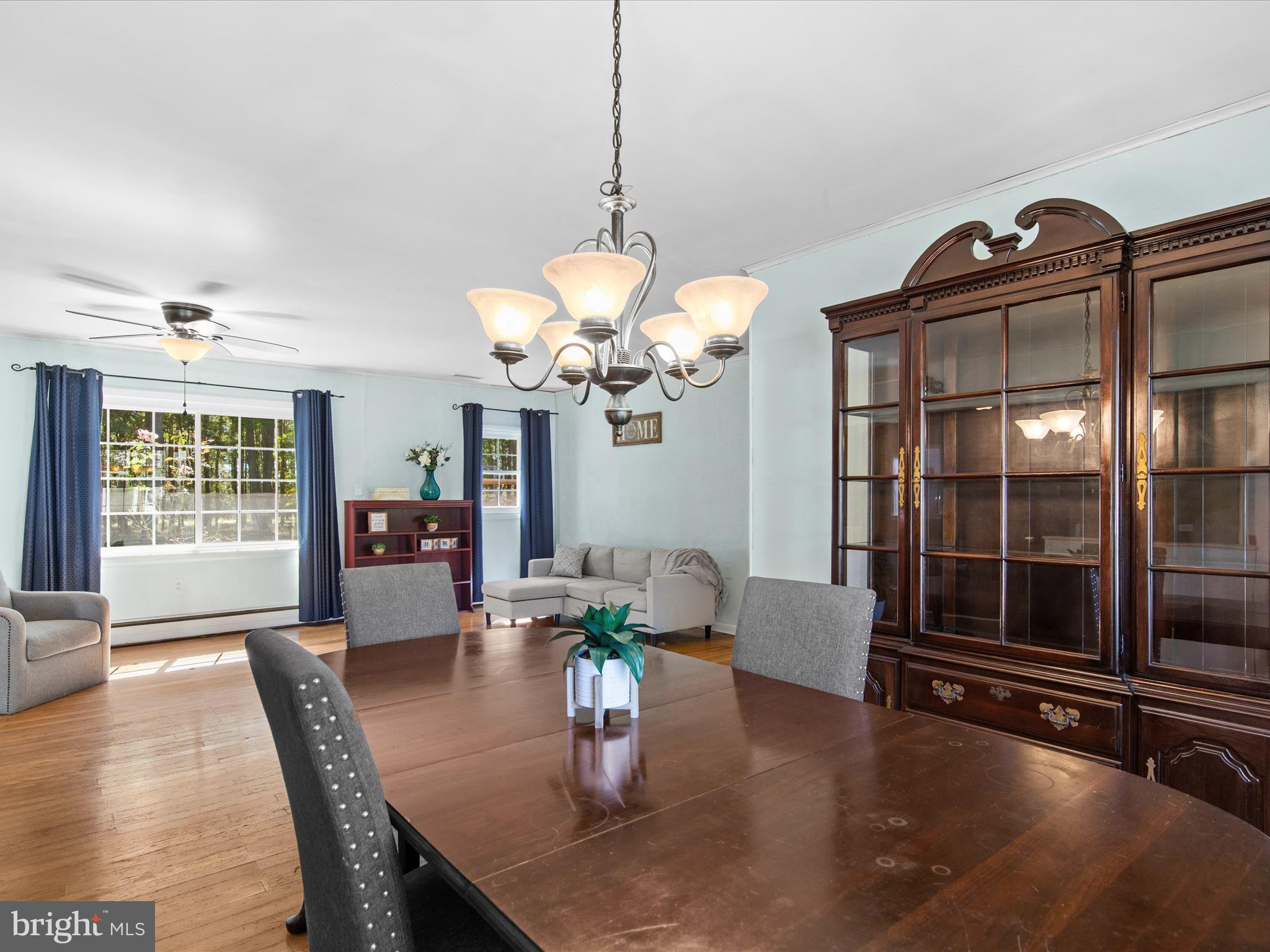 26905 Mt Vernon Road Princess Anne, MD 21853 - Photo 29 of 74 a dining room with furniture a chandelier and wooden floor