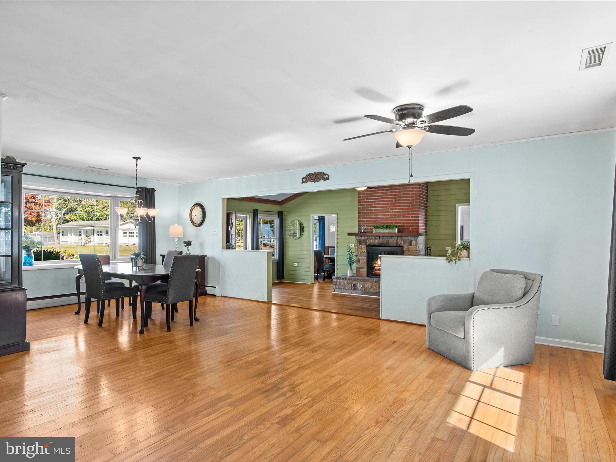 26905 Mt Vernon Road Princess Anne, MD 21853 - Photo 31 of 74 a living room with furniture a dining table and a floor to ceiling window