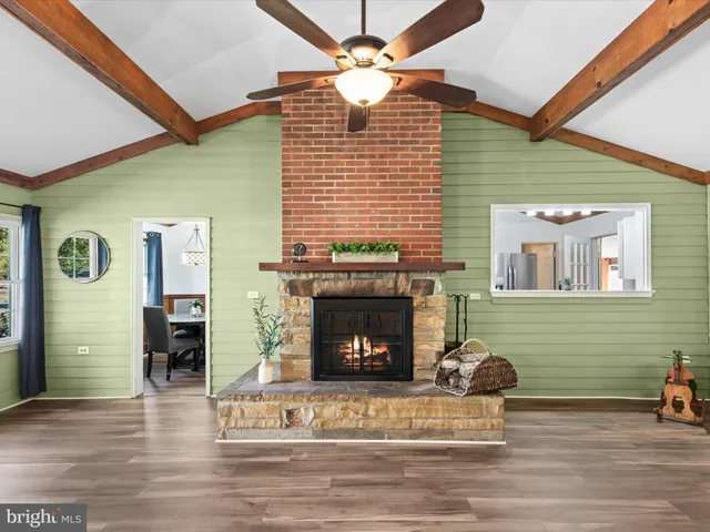 a living room with furniture a ceiling fan and a window