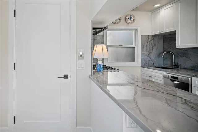 a kitchen with granite countertop a sink and a stove top oven