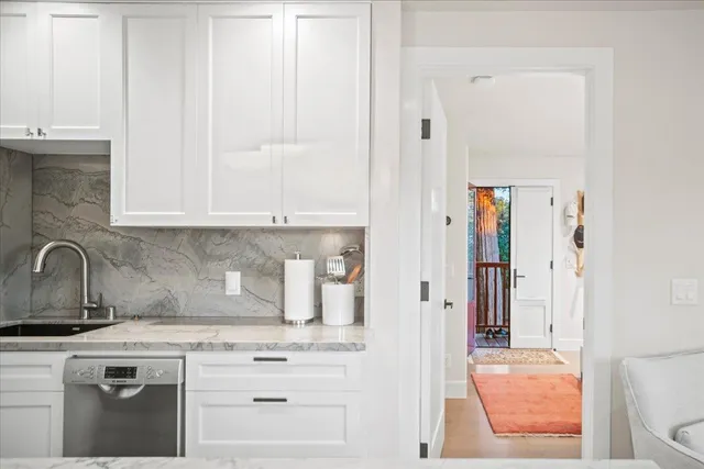 a kitchen with stainless steel appliances granite countertop white cabinets and sink