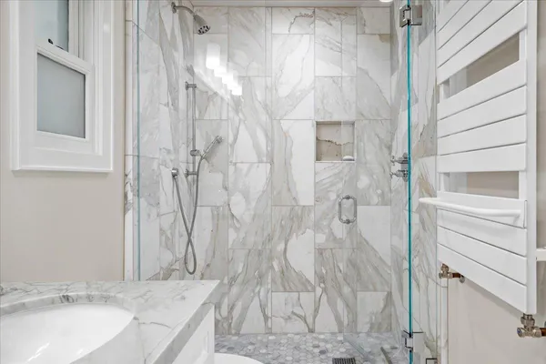 a bathroom with a granite countertop shower and a sink