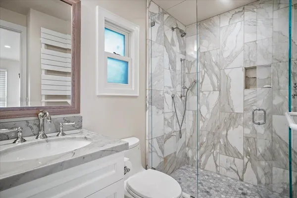 a bathroom with a granite countertop sink toilet and shower