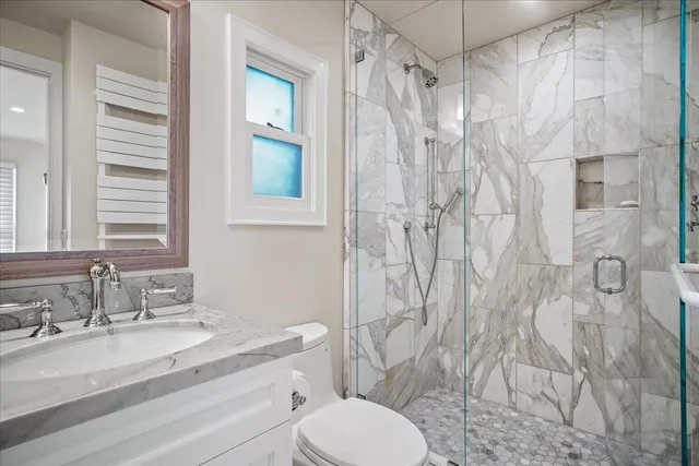 a bathroom with a granite countertop sink toilet and shower