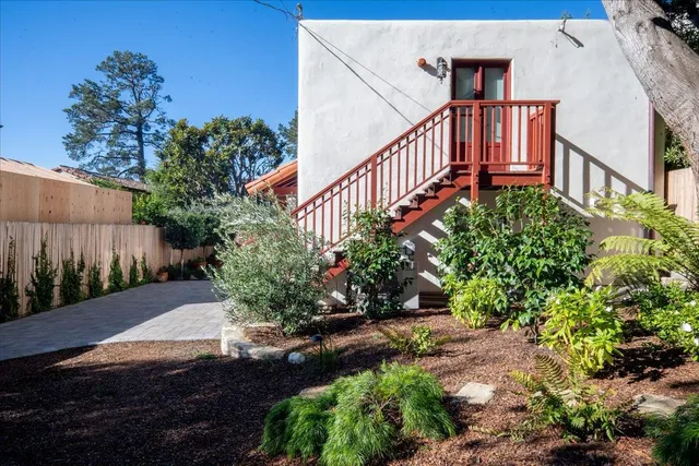 a view of a pathway of a house with wooden fence