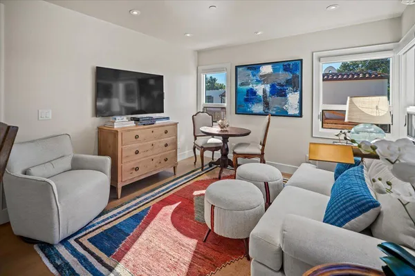 a living room with furniture a flat screen tv and paintings on the wall