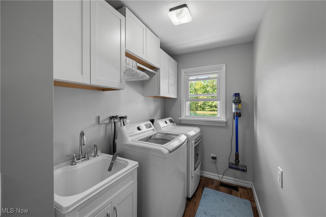 10229 Crawford Road Homerville, OH 44235 - Photo 13 of 42 Laundry room featuring cabinet space, dark wood-style flooring, and washer and clothes dryer
