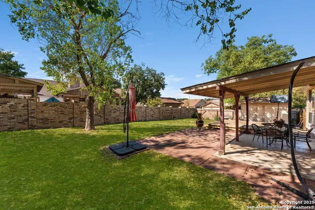 a view of backyard and wooden fence