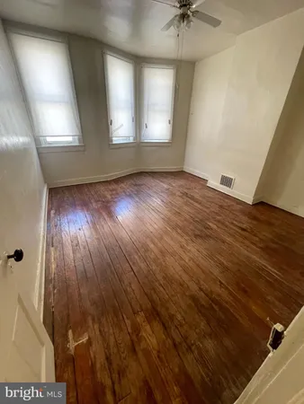 an empty room with wooden floor and stairs