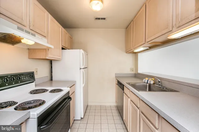 a kitchen with stainless steel appliances granite countertop a sink and a refrigerator