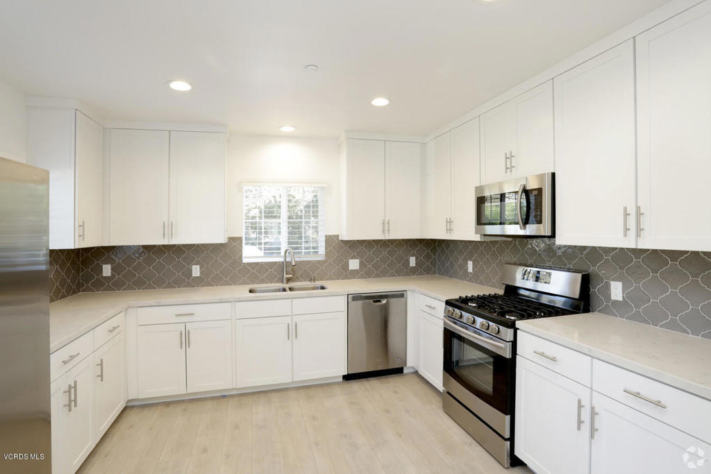 5250 Chesebro Road, Unit 13 Agoura Hills, CA 91301 - Photo 2 of 29 a kitchen with a sink stove top oven and cabinets