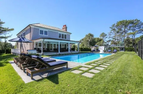 a swimming pool with outdoor seating and yard