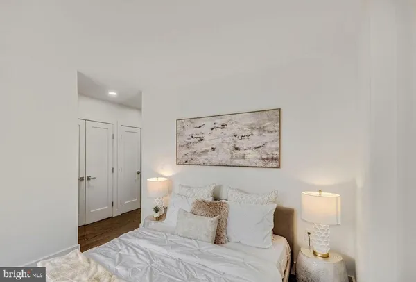 a bedroom with a bed and a painting on the wall