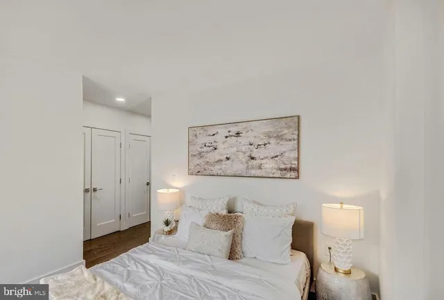 a bedroom with a bed and a painting on the wall