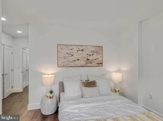 a bedroom with a bed and a painting on the wall