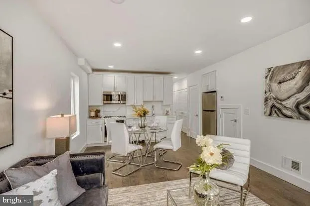 a living room with furniture kitchen view and a refrigerator