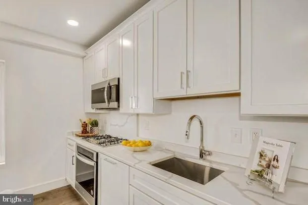 a kitchen with stainless steel appliances granite countertop a sink and a stove top oven