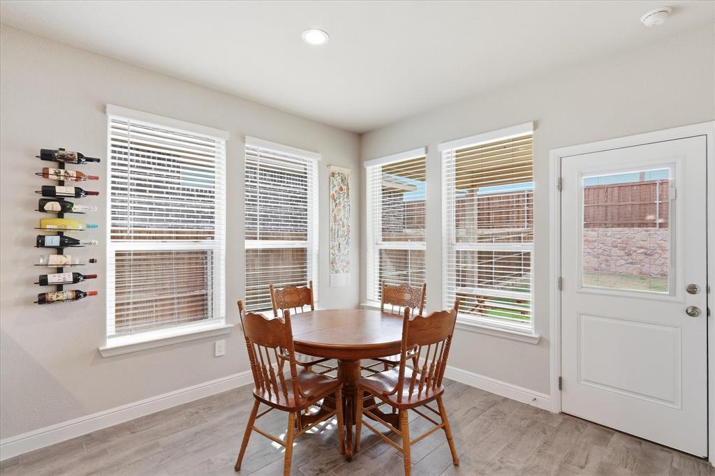 141 Medina Lane Rhome, TX 76078 - Photo 11 of 36 Recessed lighting, wood-finish flooring, multiple windows, built-in wine rack, and a glass-paneled door