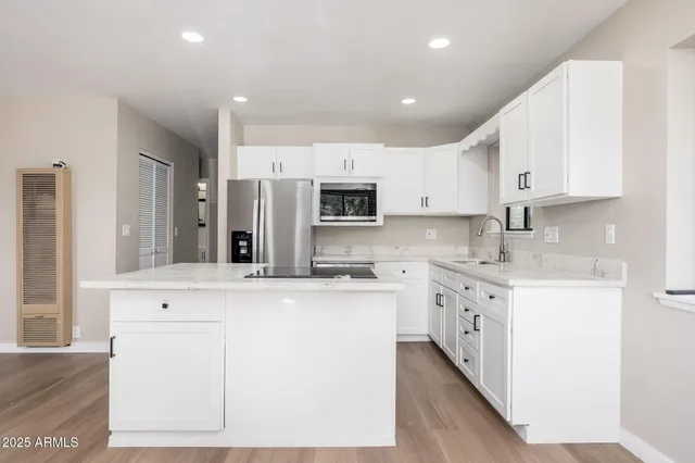 a kitchen with a sink a microwave a refrigerator and cabinets