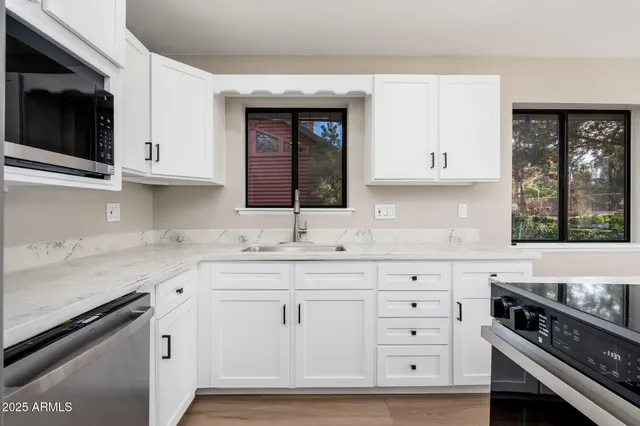 a kitchen with stainless steel appliances granite countertop a refrigerator and a stove top oven