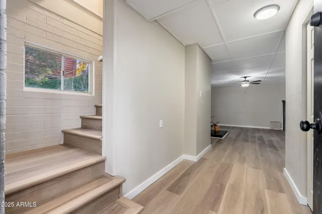 a living room with hard wood floors and a ceiling fan